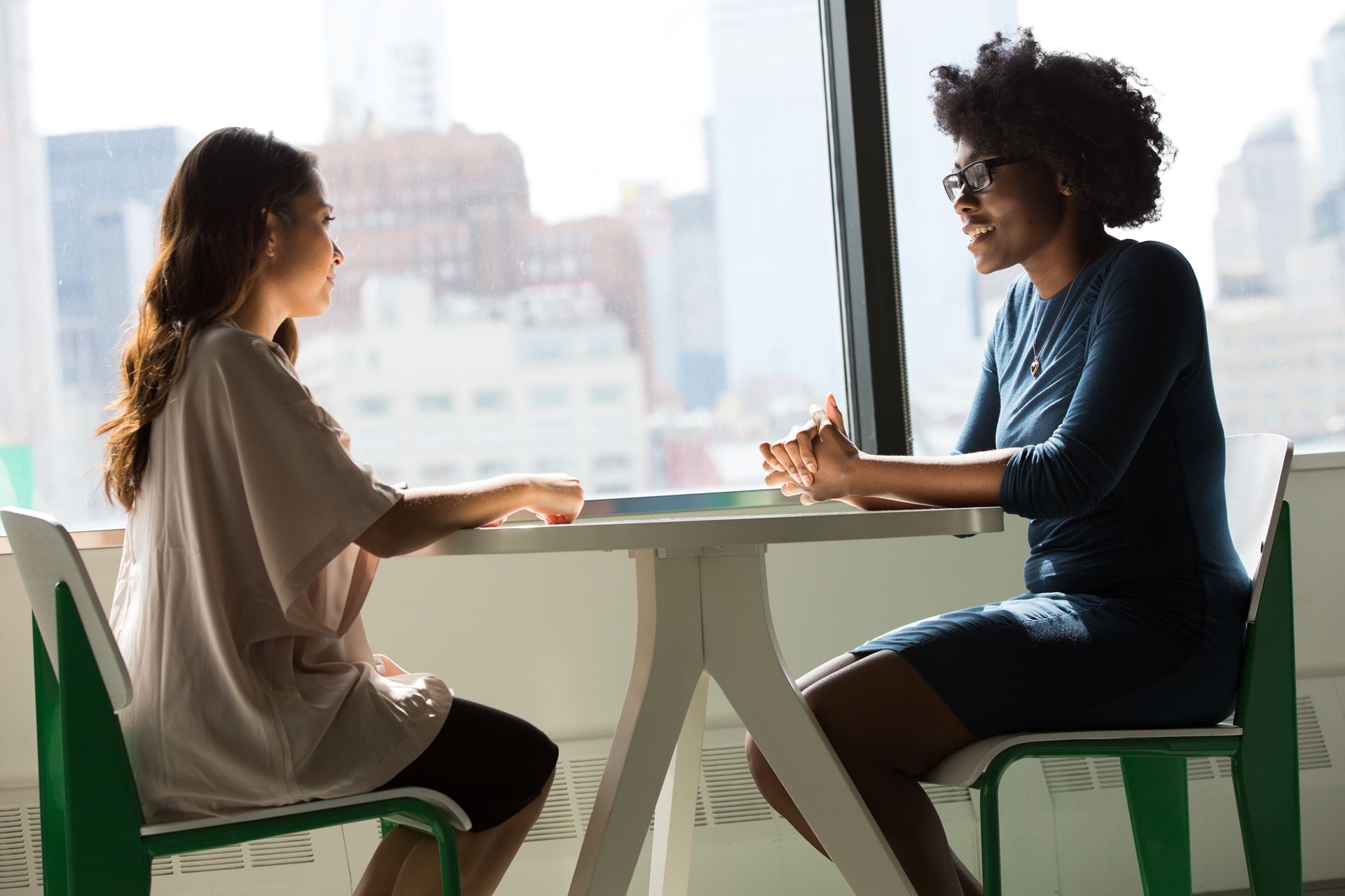 Two women talk at a table