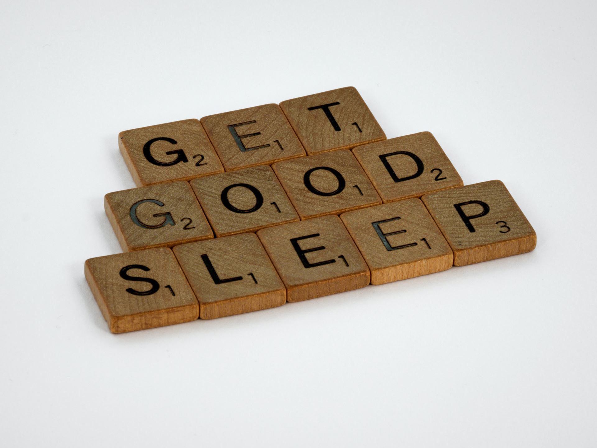 Brown wooden scrabble tiles spell out 'Get Good Sleep'