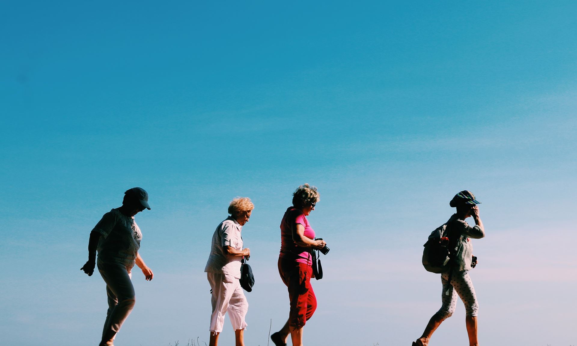 a group of people walking under a blue sky