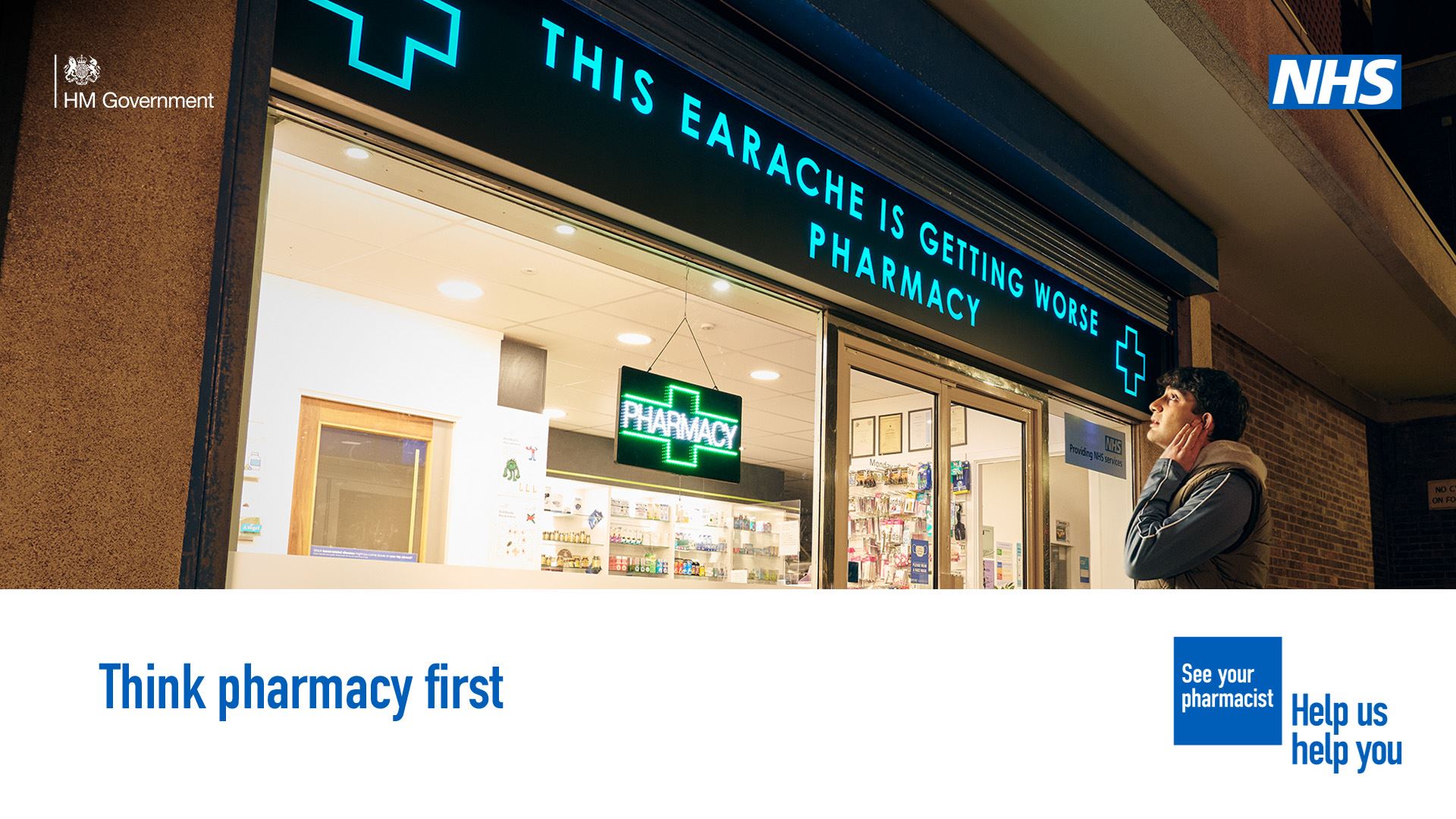 A person is standing outside a pharmacy holding the side of their face in discomfort. The sign above the pharmacy reads 'This earache is getting worse pharmacy'   A lower third box features in the bottom on the image. Text in the box reads: 'Think pharmacy first'