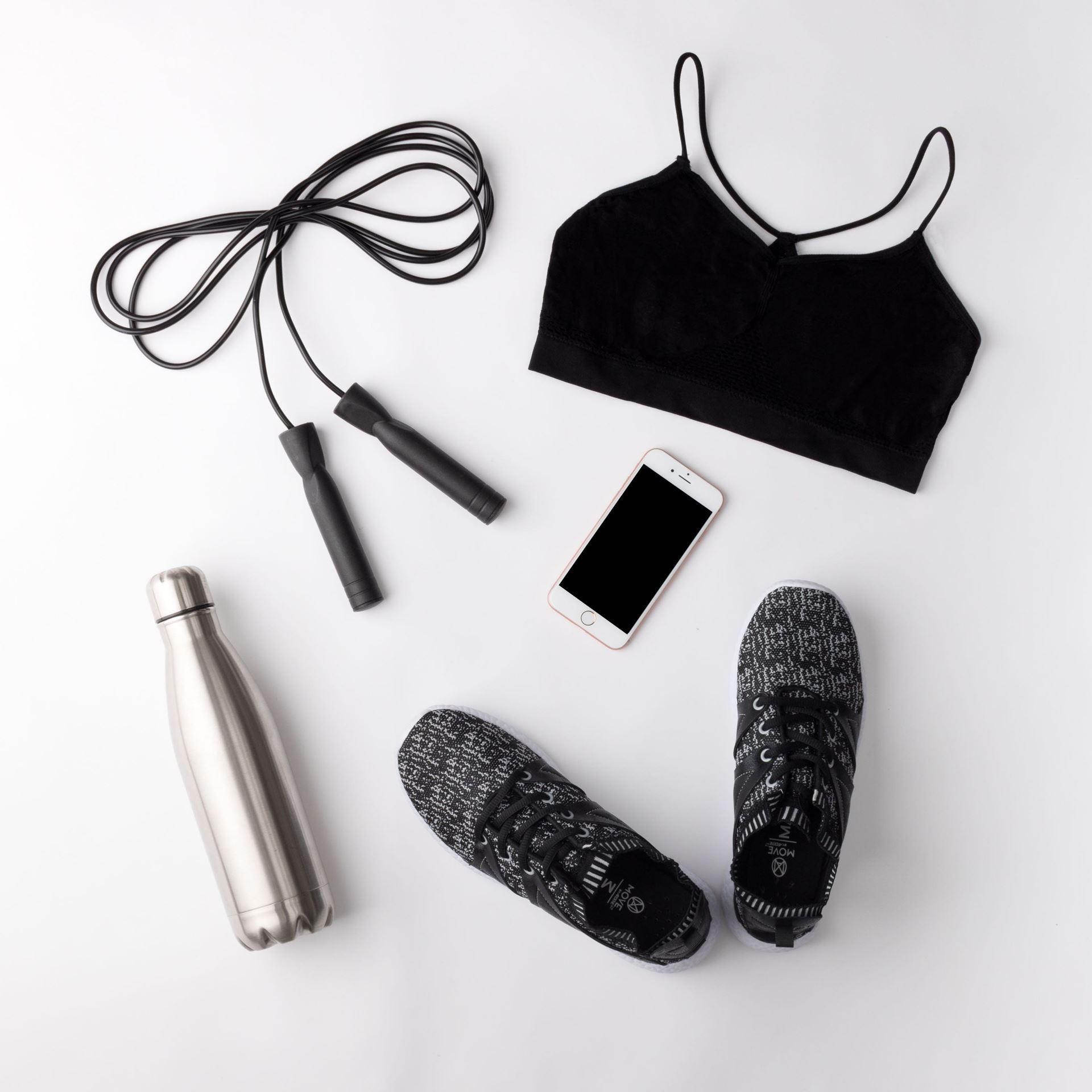 Water bottle, mobile, skipping rope, a pair of stripy black trainers, short black crop gym top